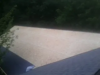 New OSB roof sheathing installed beside an existing shingle roof in Eau Claire