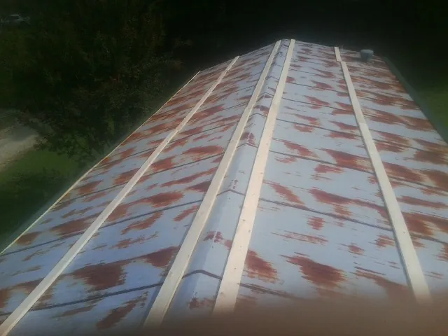 Rusted metal roof panels with new wood purlins before replacement — Storm Damage Roof Repair in Eau Claire by Roofing Brothers