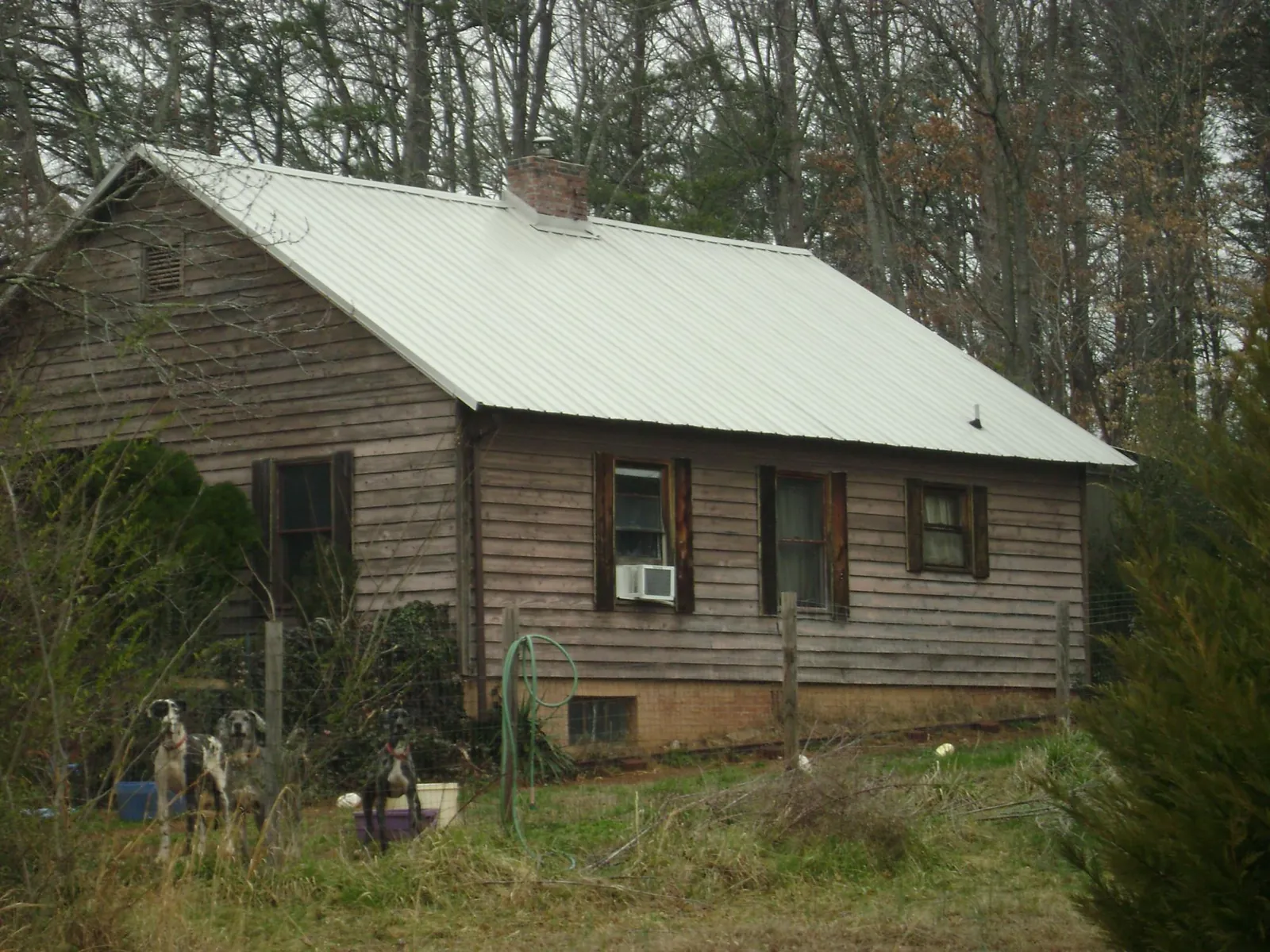 White metal roof on an old wood sided farmhouse, from a Metal Roof Installation job in Eau Claire